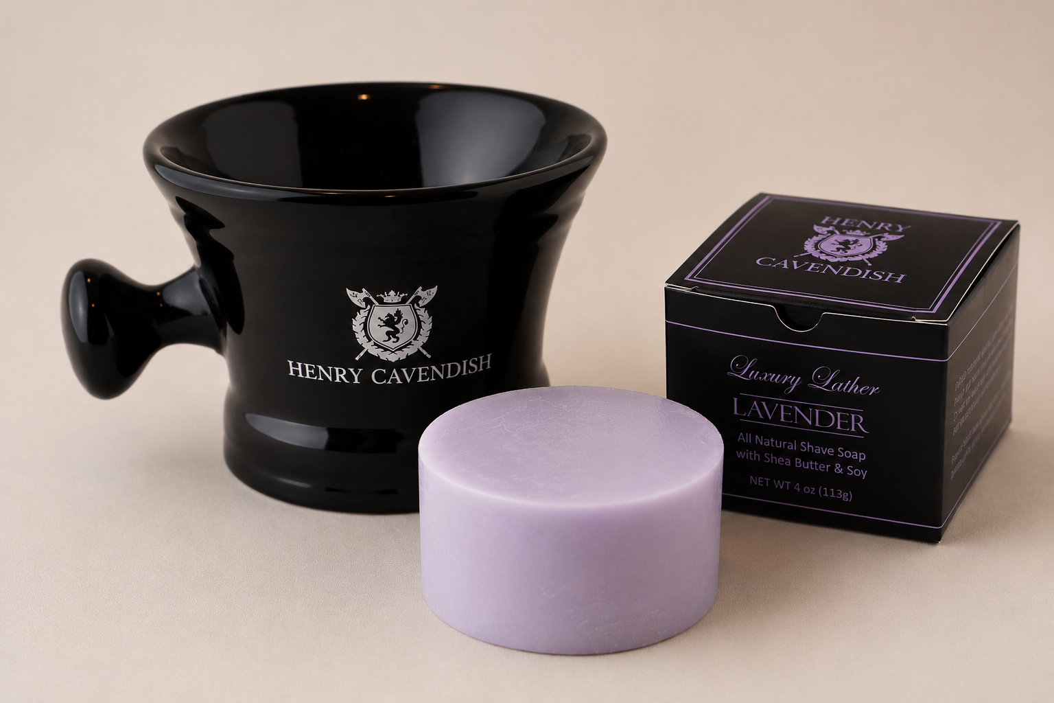 Henry Cavendish Lavender shaving soap bar in front of its black packaging box and a black ceramic shaving bowl with the brand logo, set against a neutral beige background.